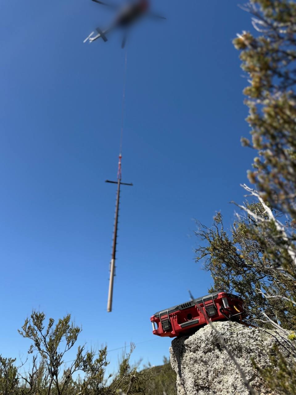 WebStar Box on a rock while a helicopter flies a power pole in overhead